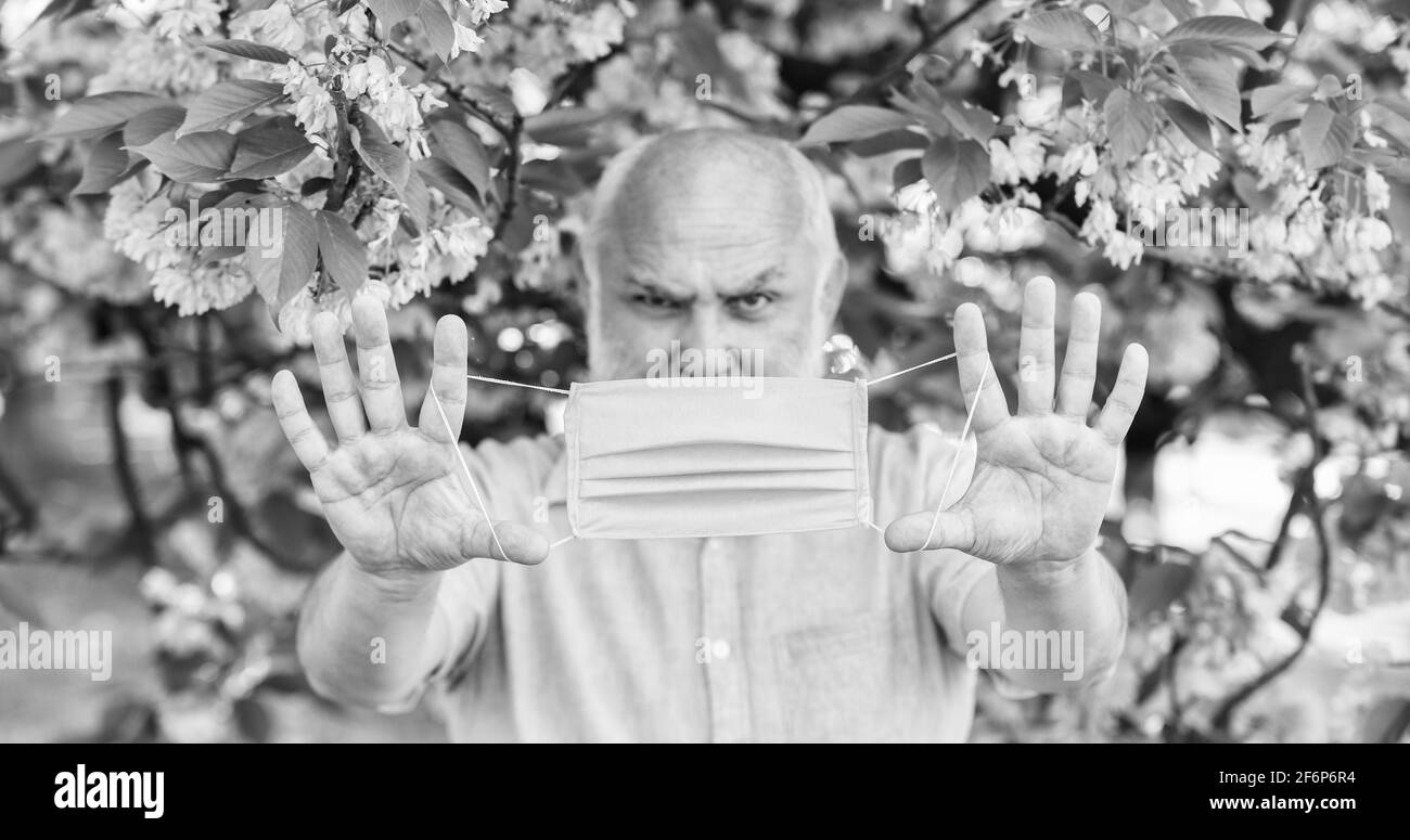 Gesichtsmaske des älteren Mannes. Atemmaske. Pollenallergen. Mann und Blumen. Atembeschwerden. Konzept der Asthmabehandlung. Atembeschwerden Stockfoto