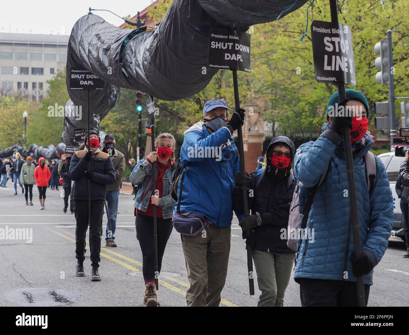 Washington, District of Columbia, USA. April 2021. Indigene Jugendliche und ihre Unterstützer trugen eine symbolische 316 Fuß lange schwarze Schlangenpuppe durch die Straßen von Washington, DC und forderten Präsident Biden auf, die Dakota Access-Ölpipeline zu schließen, den Bau der Pipeline einzustellen und die Genehmigung aller neuen Projekte für fossile Brennstoffe einzustellen. Nach der Legende von Lakota würde eine schwarze Schlange durch das heilige Land laufen und Tod und Zerstörung mit sich bringen. Die Pipeline (DAPL) wird als Manifestation dieser Vision gesehen. Quelle: Sue Dorfman/ZUMA Wire/Alamy Live News Stockfoto