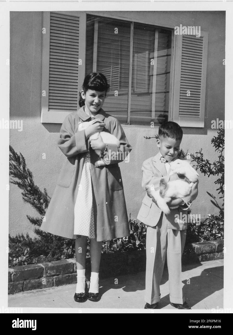 Bruder und Schwester der 1950er Jahre posieren mit Live Pet Bunnies am Ostersonntag, USA Stockfoto