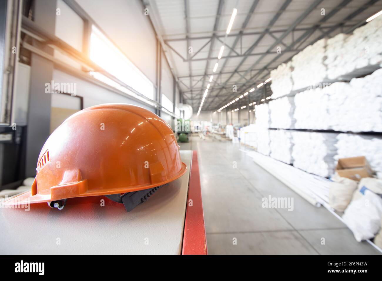 Schützende orange Hut Nahaufnahme auf dem Hintergrund von Innenräume von Industriefabriken Stockfoto