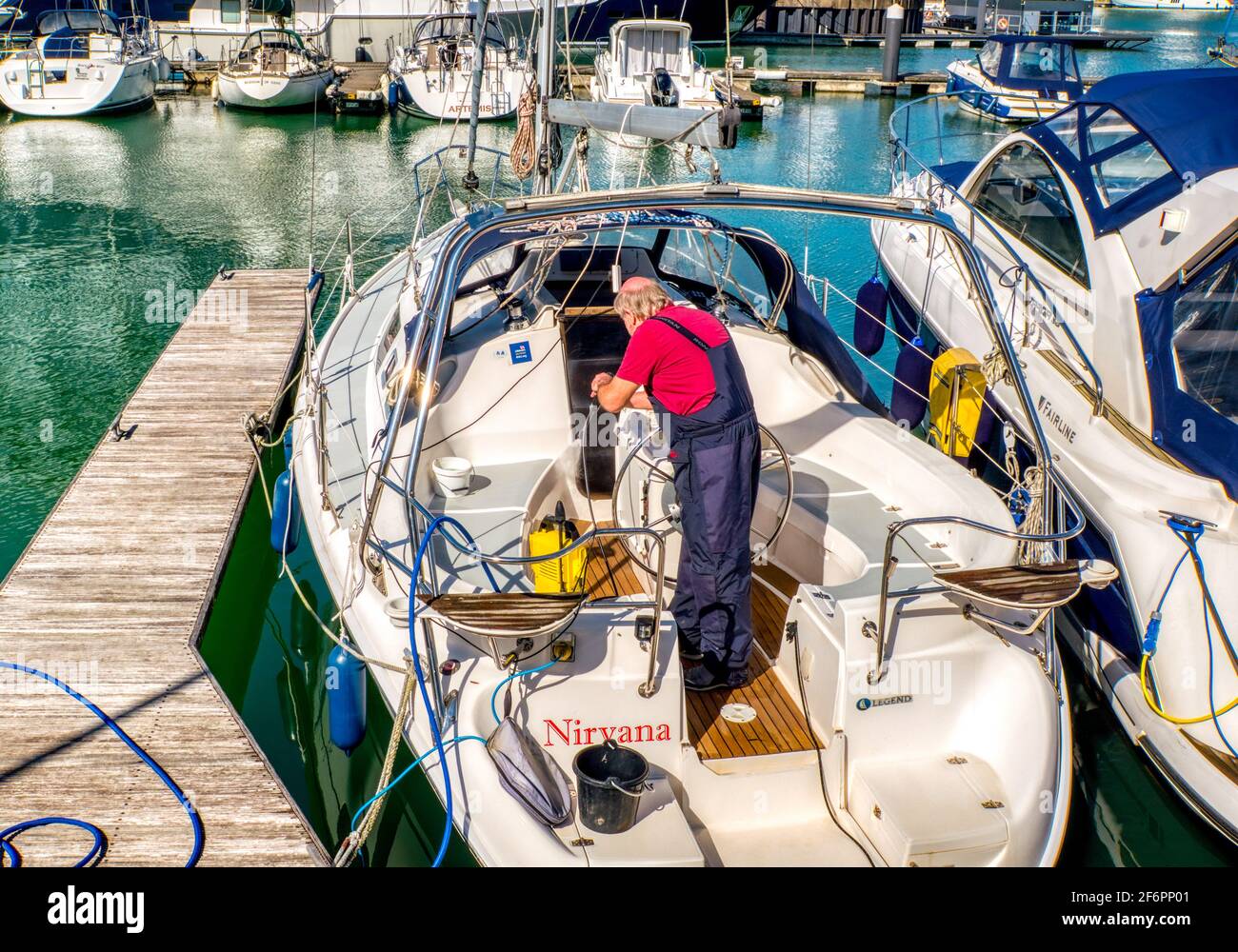Jet washing eine Yacht in Vorbereitung auf die Segel, Ocean Village Marina, Southampton, UK Stockfoto