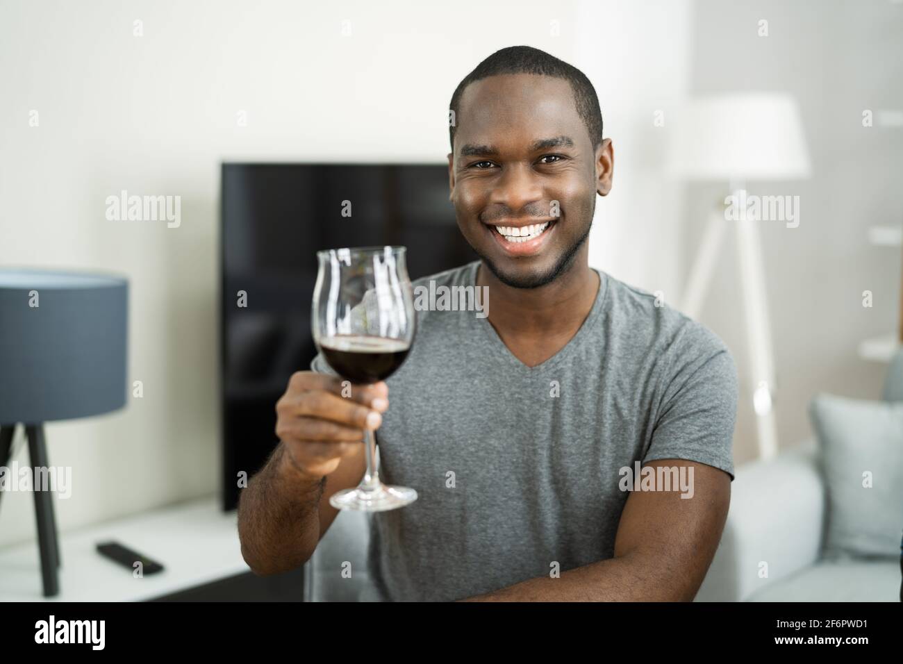 Mann Trinkt Rotwein In Video-Konferenz Zu Hause Stockfoto