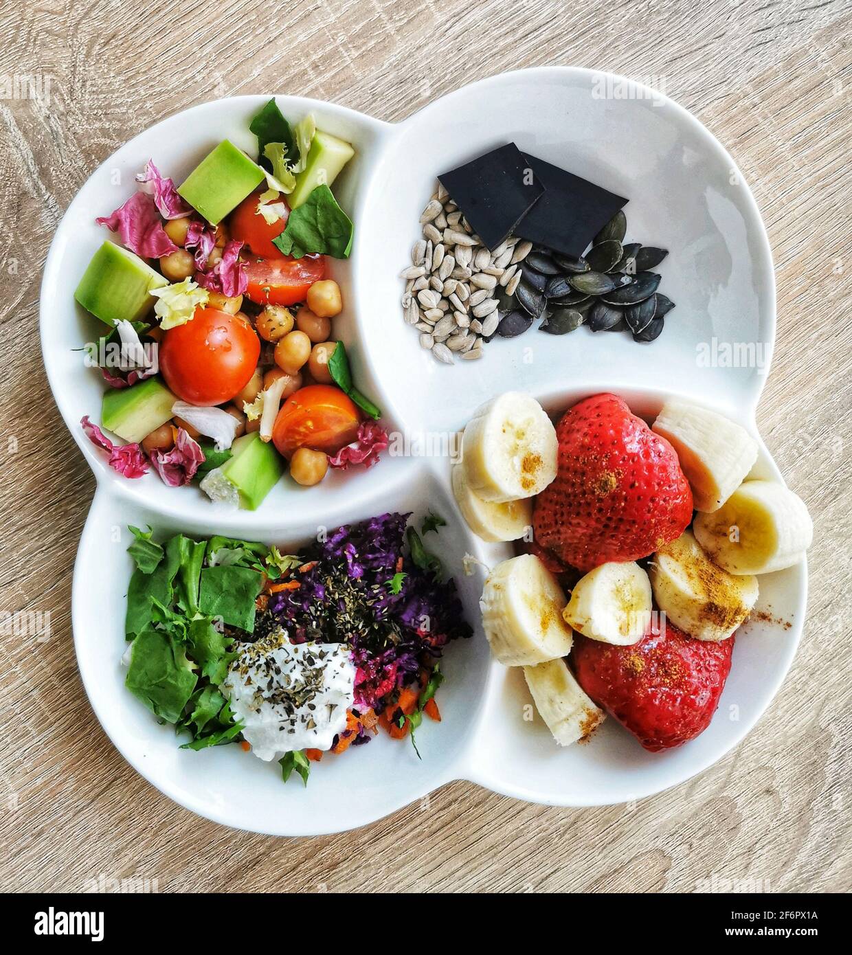 Ein gesundes, leckeres und farbenfrohes Frühstück: Kichererbsen, Tomaten, Avocado, Karotten, Spinat- und Petersilienblätter, Rotkohl Stockfoto