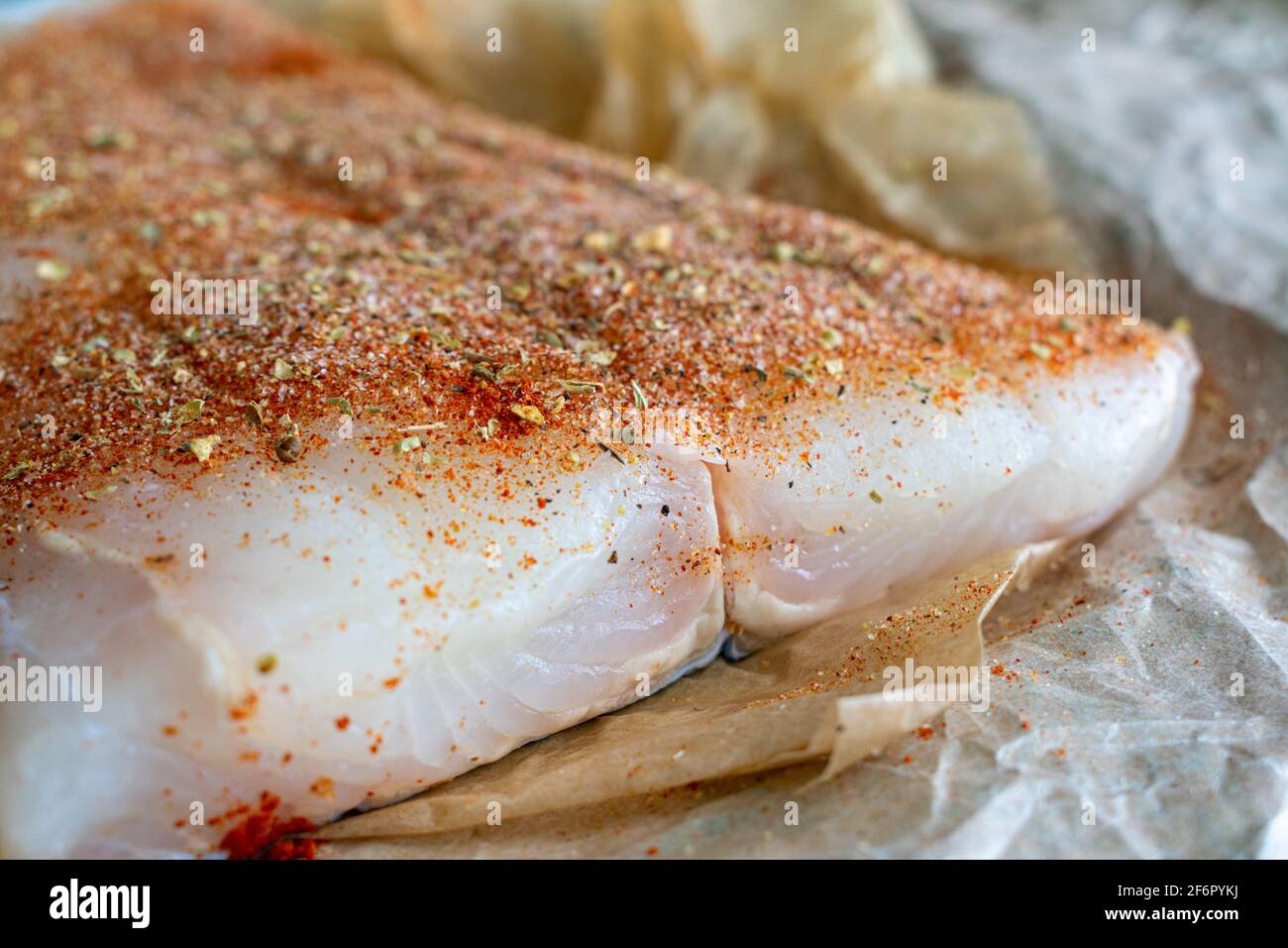 Rohes Halibut-Filet mit dem Gewürzrub von cajun: Ein ungekochtes Fischfilet, das mit Gewürzen eingerieben wurde Stockfoto
