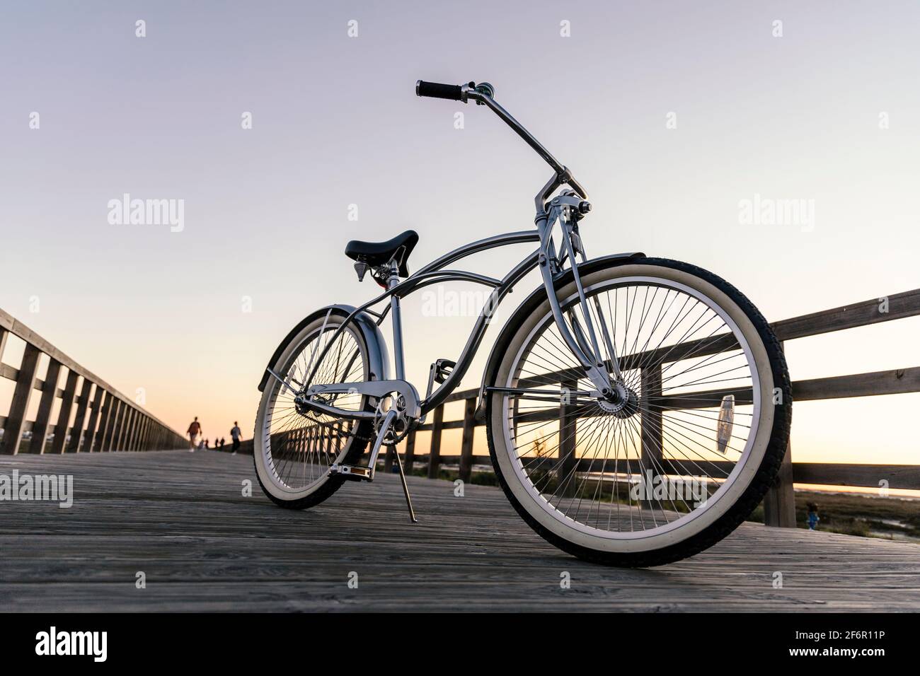 Neues Oldtimer-Fahrrad in der Mitte des Holzes geparkt Promenade bei Sonnenuntergang in Portugal Stockfoto