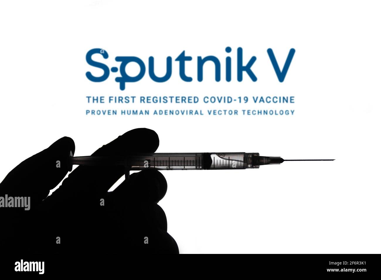 In dieser Abbildung hält eine Hand eine medizinische Spritze mit einem Sputnik V Firmenlogo auf einem Bildschirm im Hintergrund. (Foto von Rafael Henrique / SOPA Images/Sipa USA) Stockfoto