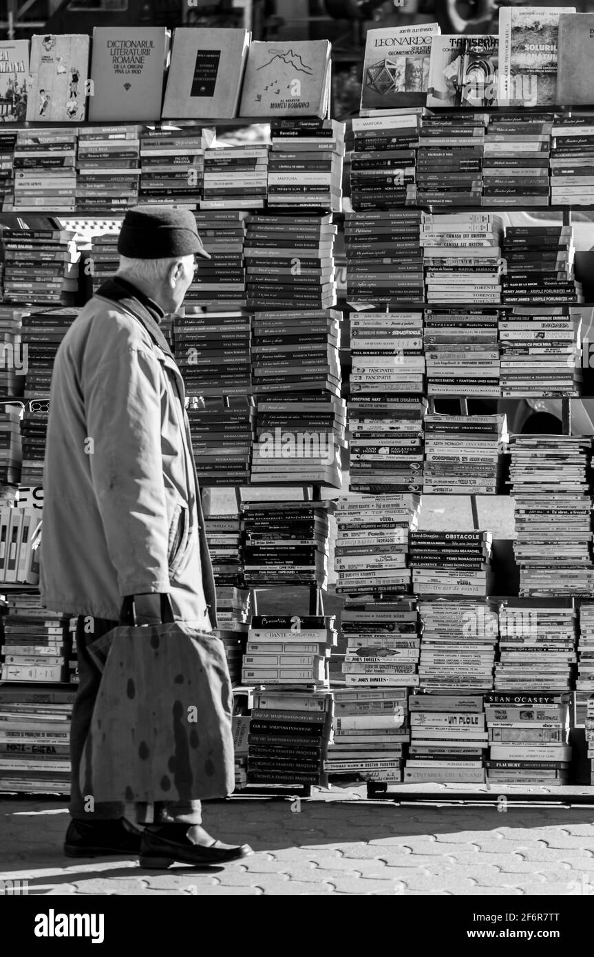 Timisoara, Rumänien - 14. März 2016: Mann schaut auf einen Bücherstand auf der Straße. Schwarz und Weiß. Stockfoto