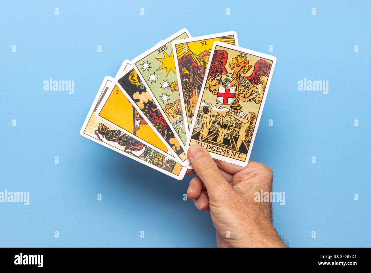 Hand hält Tarot-Karten mit der Urteilskarte am meisten. Stockfoto