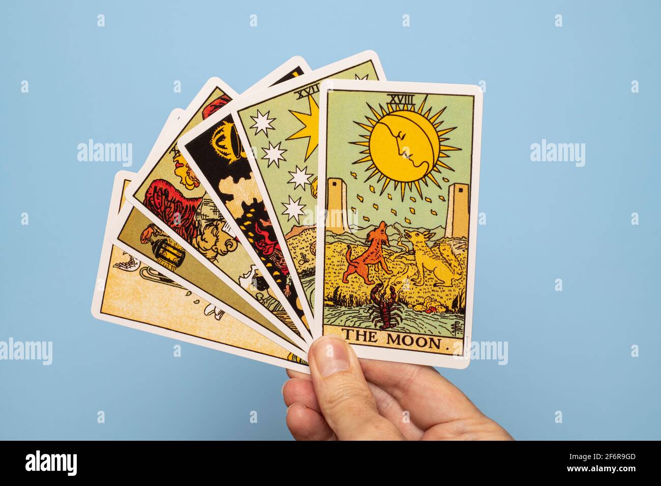 Hand hält Tarot-Karte mit dem Mond ganz oben. Stockfoto