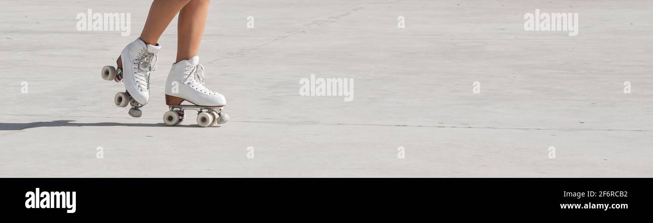 Klassische weiße Schlittschuhe für Mädchen Rollerblading auf Zement-Strecke im Freien Mit Copy Space Bannerformat Stockfoto