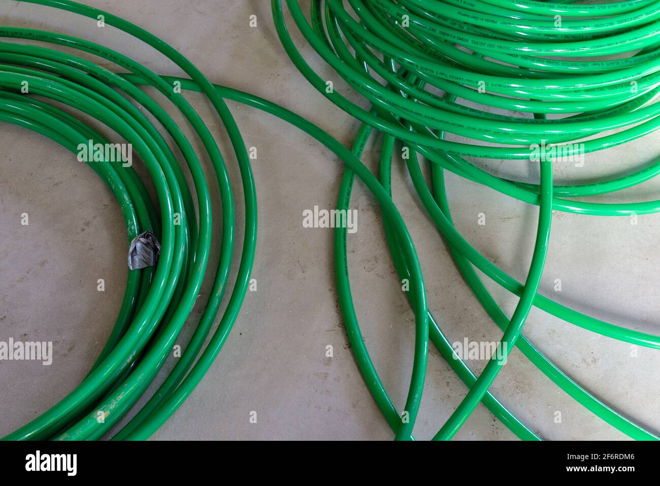 Spulen aus grünem Kunststoff Fußbodenheizung Rohr Stockfoto