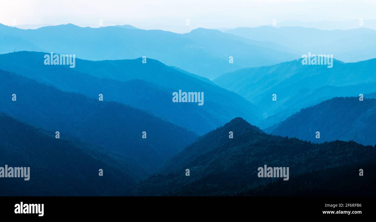 Panorama der blauen Berge. Wunderschönes Sonnenaufgangslicht im Hintergrund. Landschaftsfotografie Stockfoto