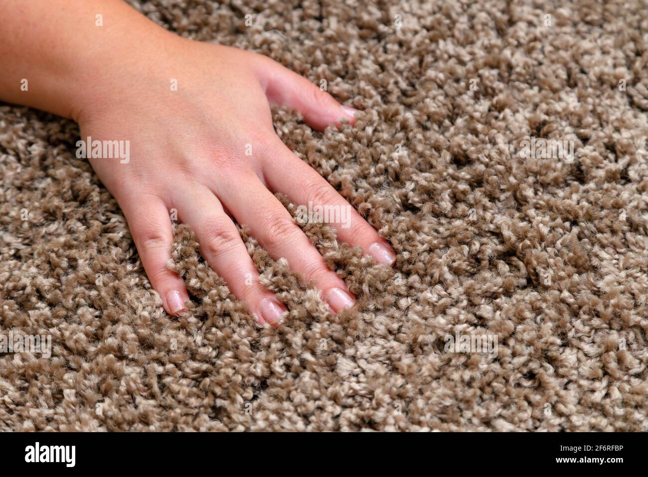 Nahaufnahme der Hand berühren weichen Teppich. Weicher und flauschiger Teppich zwischen den Fingern. Stockfoto