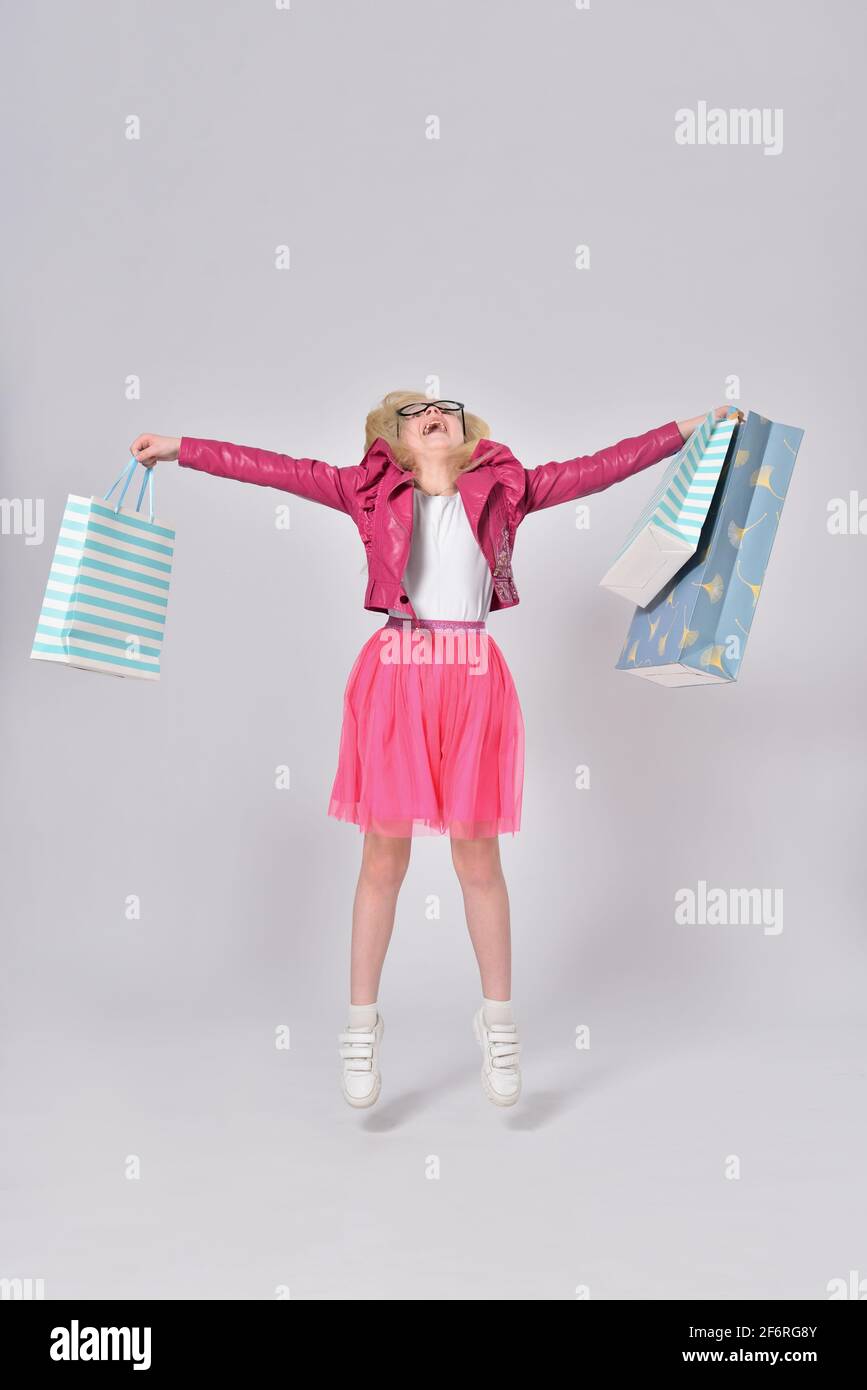 Teen Mädchen springen mit Papiertüten nach dem Einkaufen Stockfoto
