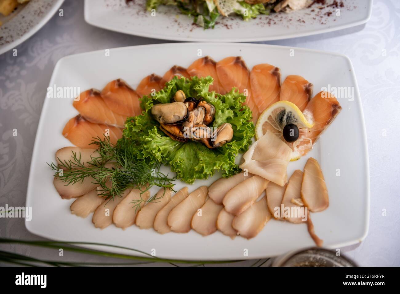 Schneiden verschiedener Fischarten. Schneiden von roten und weißen Fischen. Festlicher Tisch Stockfoto