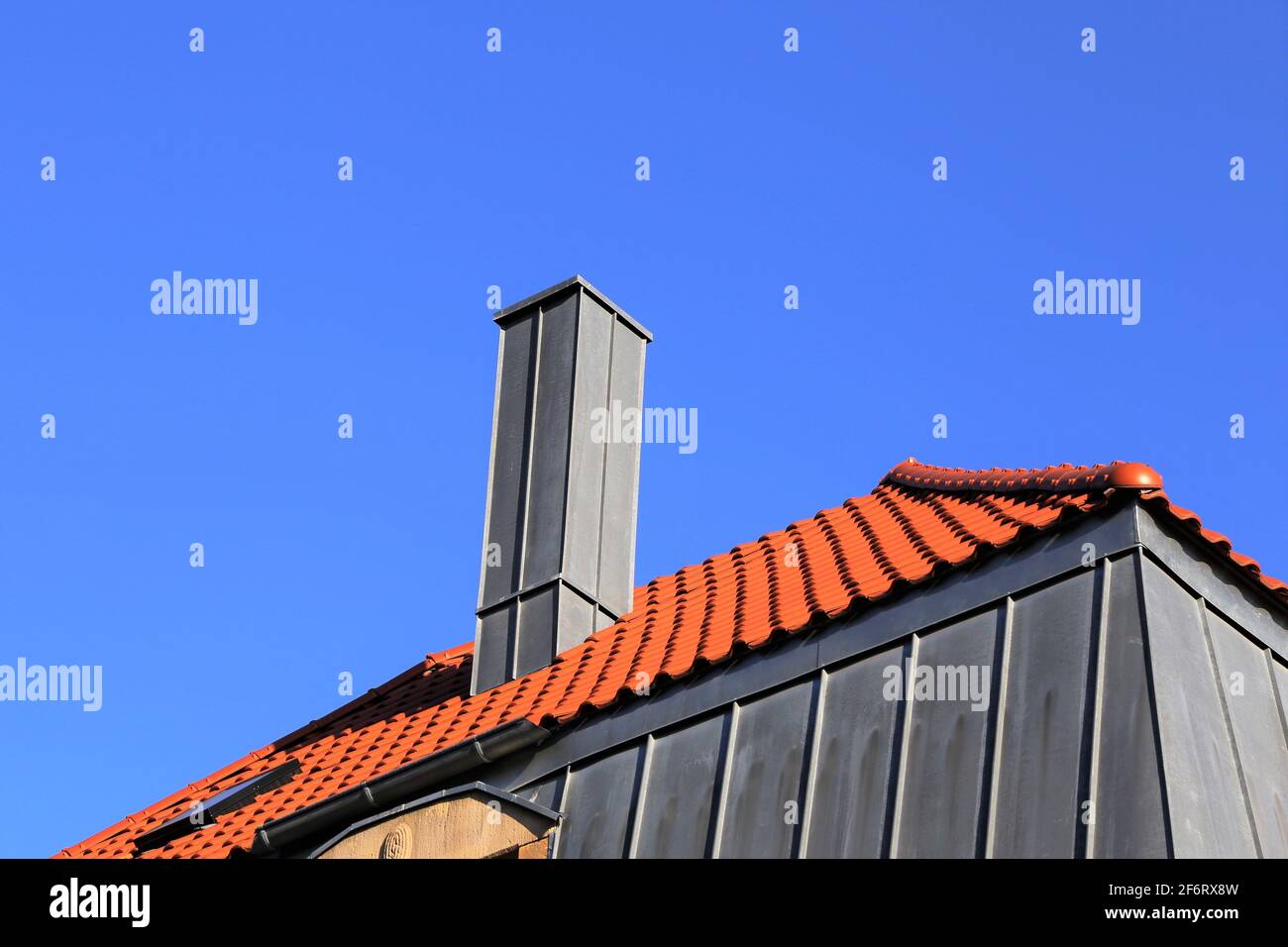 Schornstein mit Edelstahlverkleidung auf einem neu überdachten Dach. Stockfoto