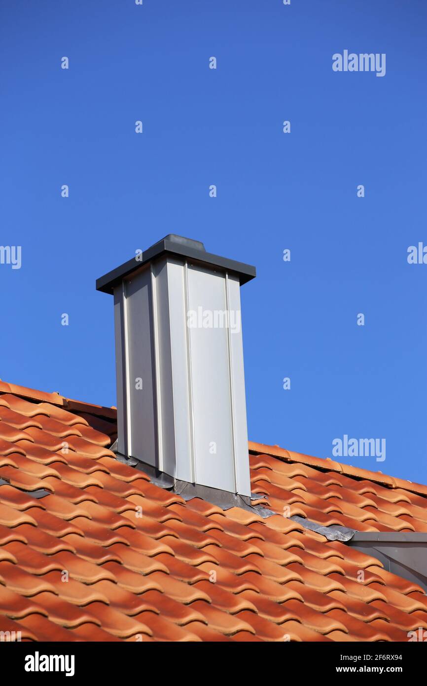 Schornstein mit Edelstahlverkleidung auf einem neu überdachten Dach. Stockfoto