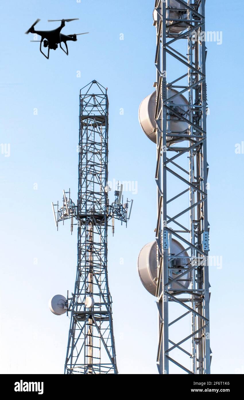 Antennenkalibrierung mit Drohne. Telekommunikationstürme mit blauem, klarem Himmel. Stockfoto