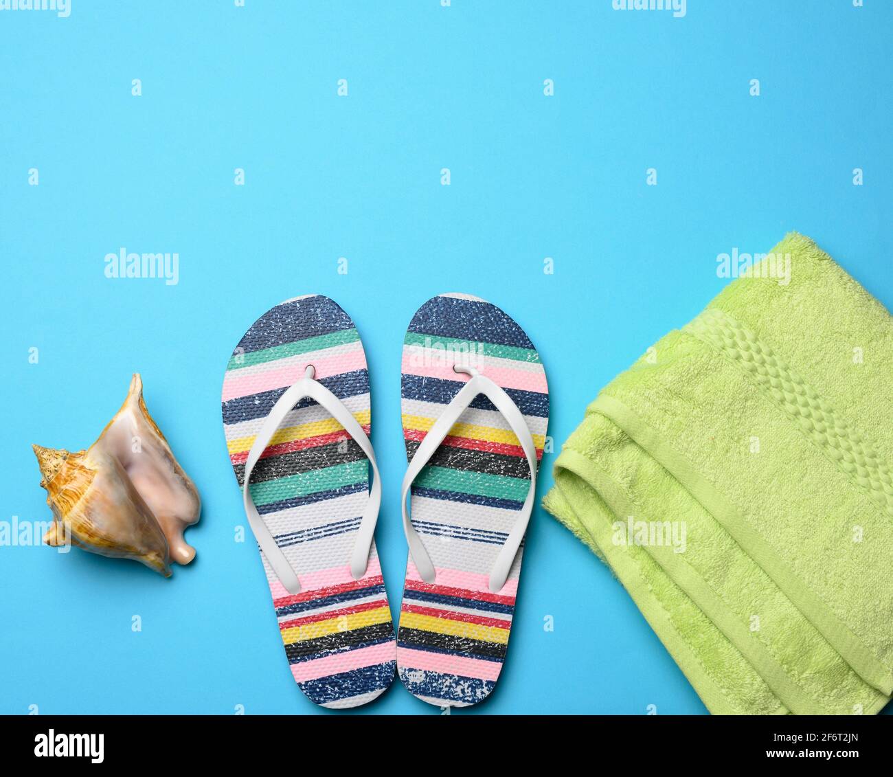 Gummi-Damen gestreifte Hausschuhe auf einem blauen Hintergrund, Draufsicht, Platz für eine Inschrift. Stockfoto