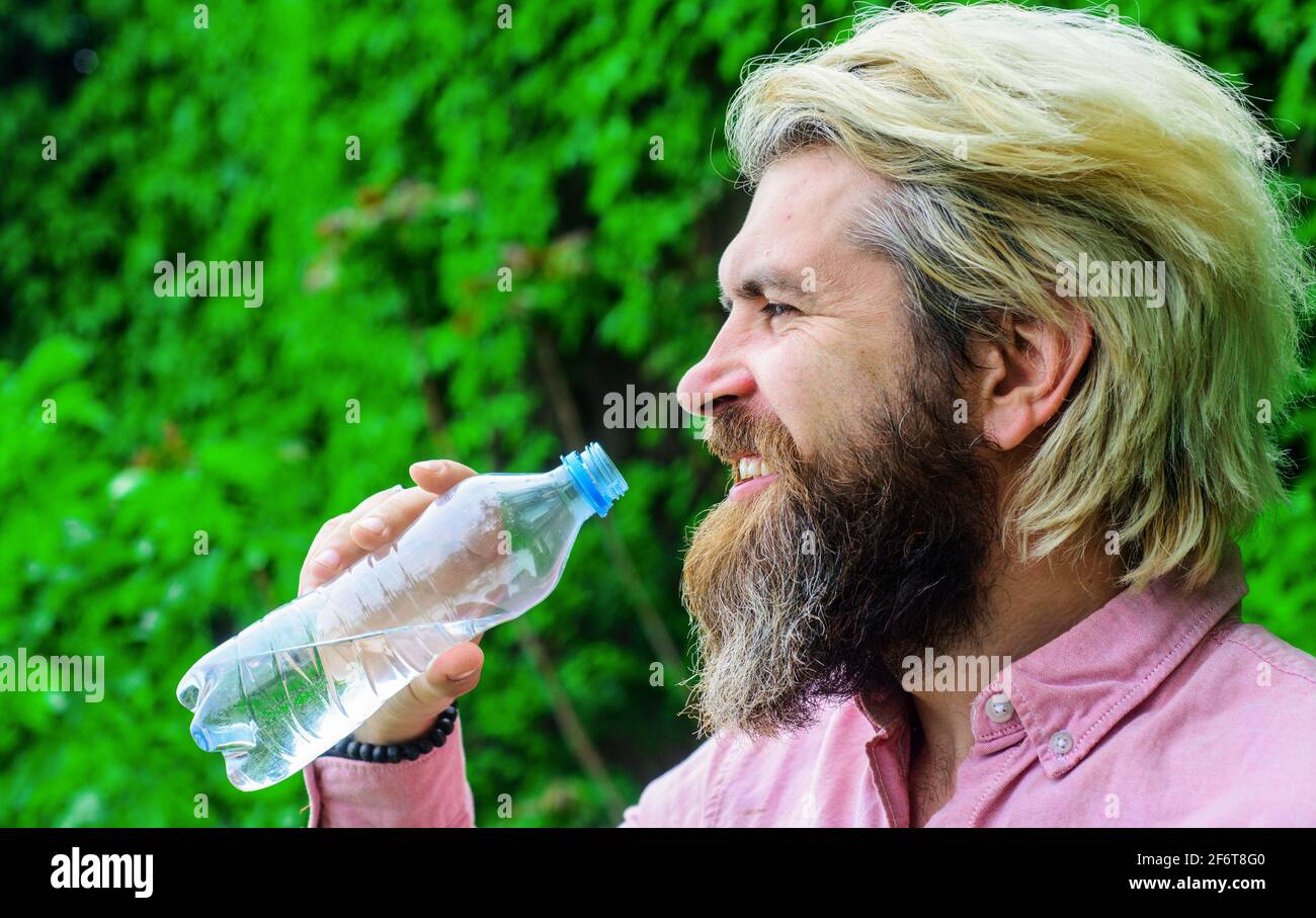 Mann trinkt Wasser im Freien. Bärtiger Rüde mit Wasserflasche. Gesunder Lebensstil. Trinkwasser Stockfoto