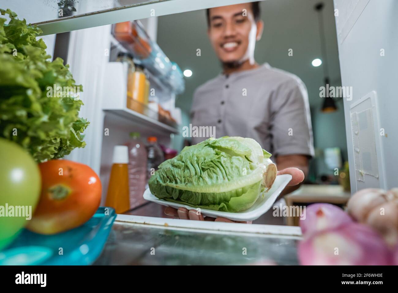 asiatischer Mann nimmt Zutaten aus dem Kühlschrank, um zu kochen  Stockfotografie - Alamy