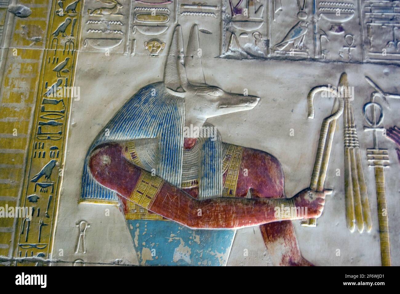 Nahaufnahme einer bemalten Hieroglyphen-Schnitzerei des altägyptischen gottes Anubis. Anubis ist mit dem Kopf eines Schakals dargestellt und der gott der Mumifizierung Stockfoto