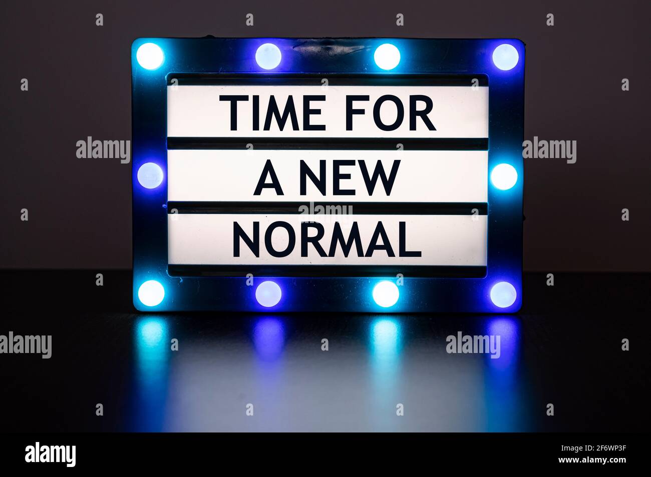 Leuchtkasten mit blauen Lichtern im dunklen Raum mit Worten - Zeit für eine neue Normalität. Stockfoto