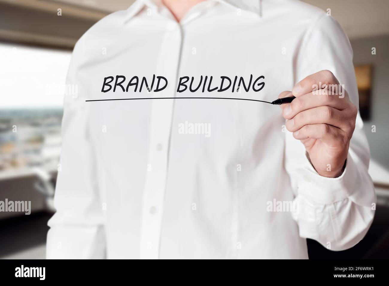 Businessman Hand hält einen Stift und unterstreicht die Worte Brand Building auf dem virtuellen Bildschirm. Geschäftsmarketing-Konzept. Stockfoto