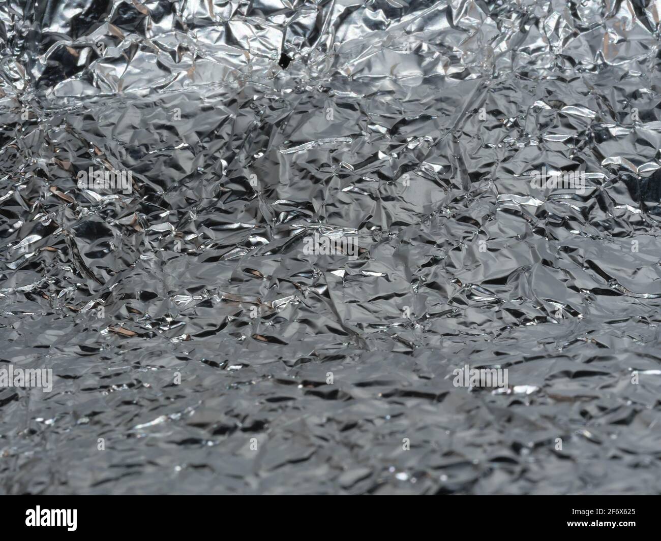 Dünne Blatt von silbernem Blatt Hintergrund mit glänzenden unebenen Oberfläche Stockfoto