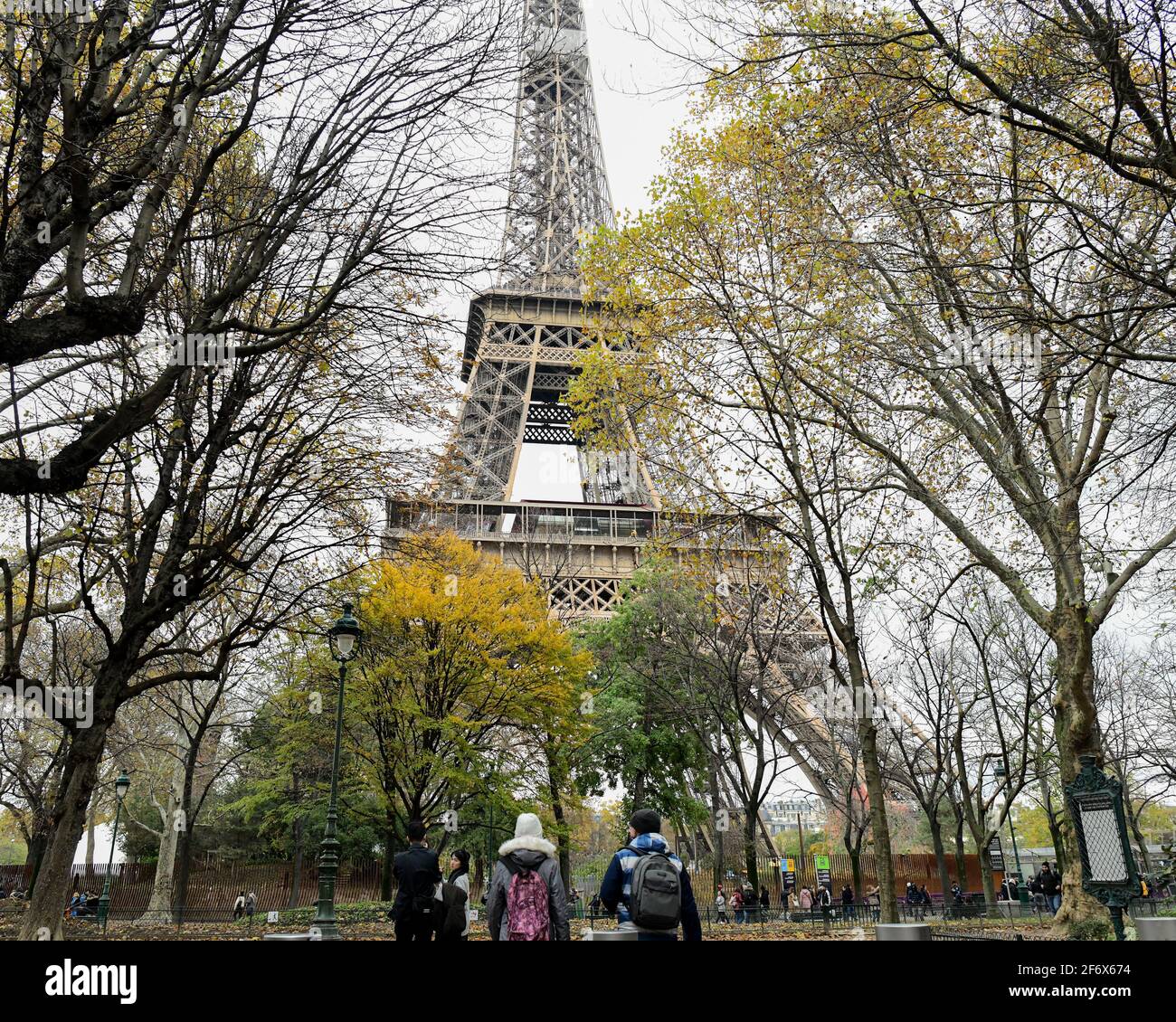 Paris, 18. November 2019: Männliche und weibliche Touristen schauten auf den berühmten Eiffelturm von Paris, Frankreich Stockfoto