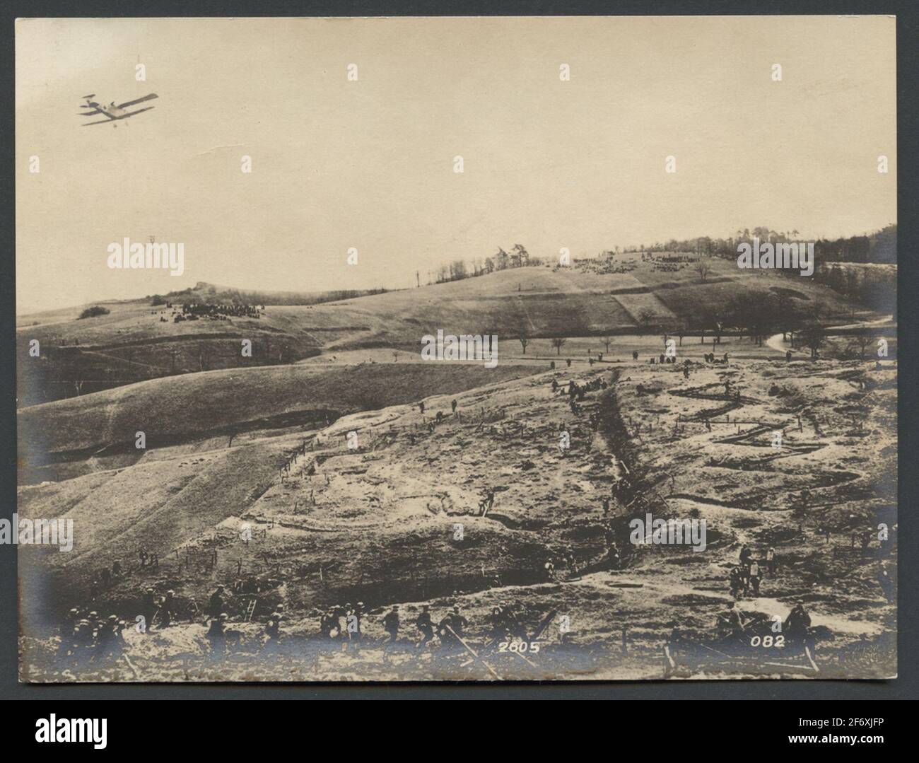 Das Bild zeigt eine hügelige Landschaft mit einem Hindernisparcours für die Ausbildung von Soldaten.über dem Feld passiert ein Flugzeug.Originaltext: 'Hinter der Deutschen Front befindet sich ein Übungsfeld, das mit allen Hindernissen, Granatlöchern, Regionen usw. eingerichtet ist, um den realen Bedingungen an der hauptlinia zu entsprechen. Das Bild zeigt die Zusammenarbeit der Infanterie mit einer sogenannten Infanterie, die mit Maschinengewehren und Bomben die feindlichen Schützencrews angreift. Das Bild zeigt eine hügelige Landschaft mit einem Hindernislauf für die Ausbildung von Soldaten.über dem Feld passiert ein Flugzeug.Originaltext: 'Hinter der Deutschen Front L Stockfoto