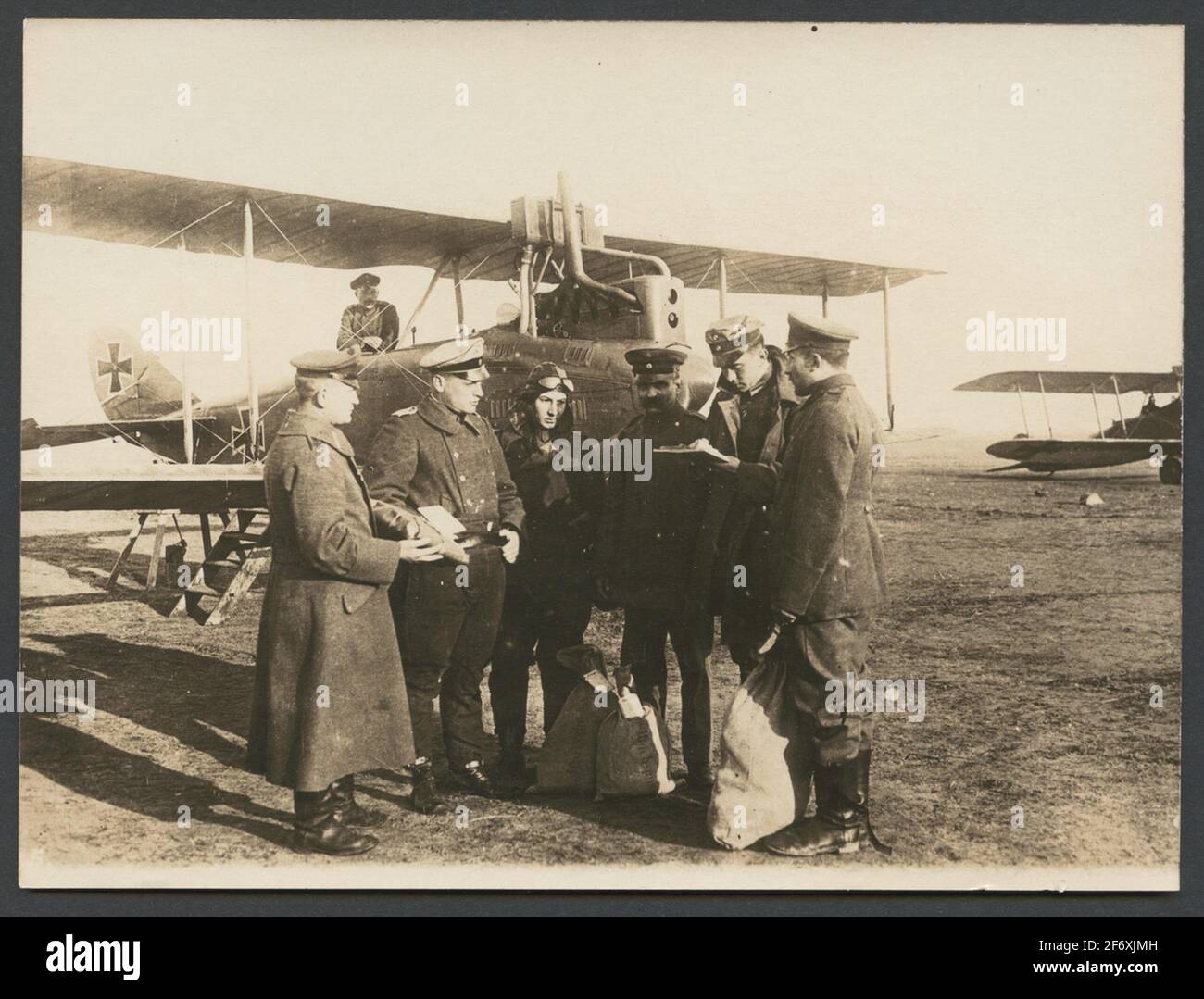 Das Bild zeigt, wie mehrere Männer in Uniform mit Postdiensten und Dokumenten umgehen.im Hintergrund zwei Doppeldecker-Flugzeuge.Originaltext: 'Der Flugoffizier erhält die Brieftaschen und die Wertsendungen.'.das Bild zeigt, wie mehrere Männer in Uniform mit Postdiensten und Dokumenten umgehen.im Hintergrund zwei Doppeldecker-Flugzeuge. Stockfoto