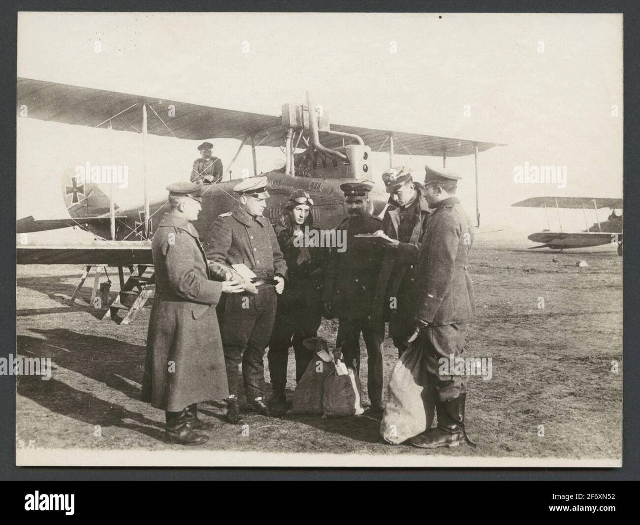 Das Bild zeigt, wie mehrere Männer in Uniform mit Postdiensten und Dokumenten umgehen.im Hintergrund zwei Doppeldecker-Flugzeuge.Originaltext: 'Der Flugoffizier erhält die Brieftaschen und die Wertsendungen.'.das Bild zeigt, wie mehrere Männer in Uniform mit Postdiensten und Dokumenten umgehen.im Hintergrund zwei Doppeldecker-Flugzeuge. Stockfoto