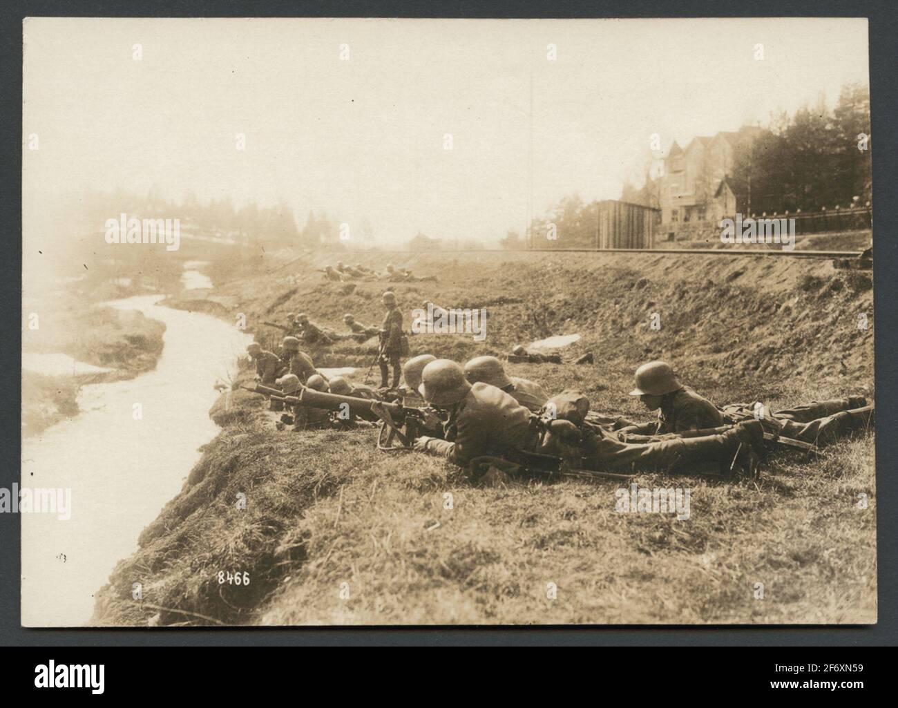 Das Bild zeigt eine Gruppe von Soldaten mit Maschinengewehren, die auf dem Boden zwischen einer Eisenbahnschiene und einem kleinen liegen. Die Soldaten sind mit einer Maschine mg 08/15 ausgestattet.EIN Mann steht aufrecht in der Mitte und viele Soldaten schauen ihn an.die Szenerie scheint recht entspannt zu sein für einen andauernden Kampf, den der Originaltext besagt.Originaltext: "Deutsche Schusswaffe im Kampf mit Rotgardisten bei der Eisenbahn Hanko healthfors."das Bild zeigt eine Gruppe von Soldaten mit Maschinengewehren, die auf dem Boden zwischen einer Eisenbahnschiene und einem kleinen liegen. Die Soldaten sind mit der Maschine mg 08/15 ausgestattet.EIN Mann steht auf Stockfoto