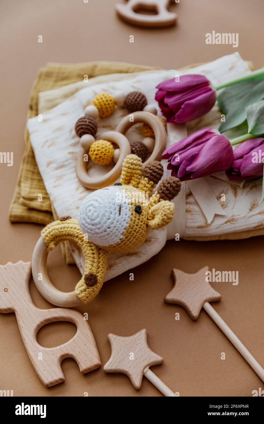 Set aus Spielzeug, Zubehör und Aufbrennlappen mit frischen Tulpen für ein neugeborenes Baby Stockfoto