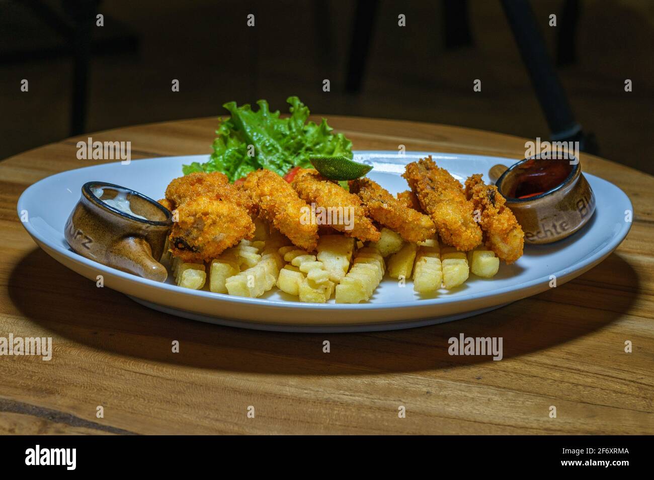 Fisch-Goujons mit Pommes frites, Ketchup und Tartarsauce Stockfoto
