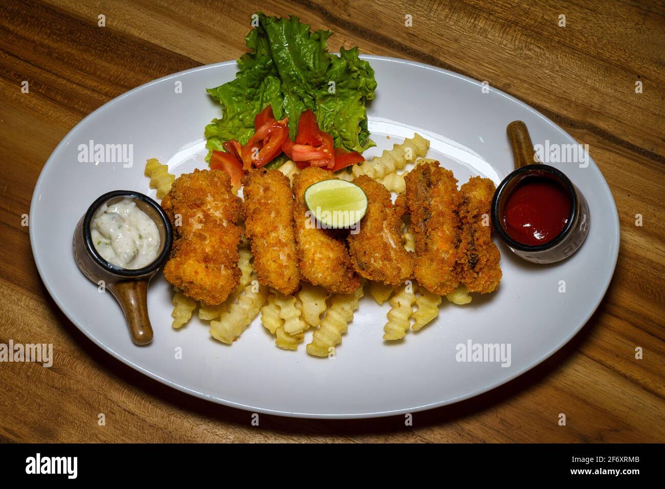 Fisch-Goujons mit Pommes frites, Ketchup und Tartarsauce Stockfoto