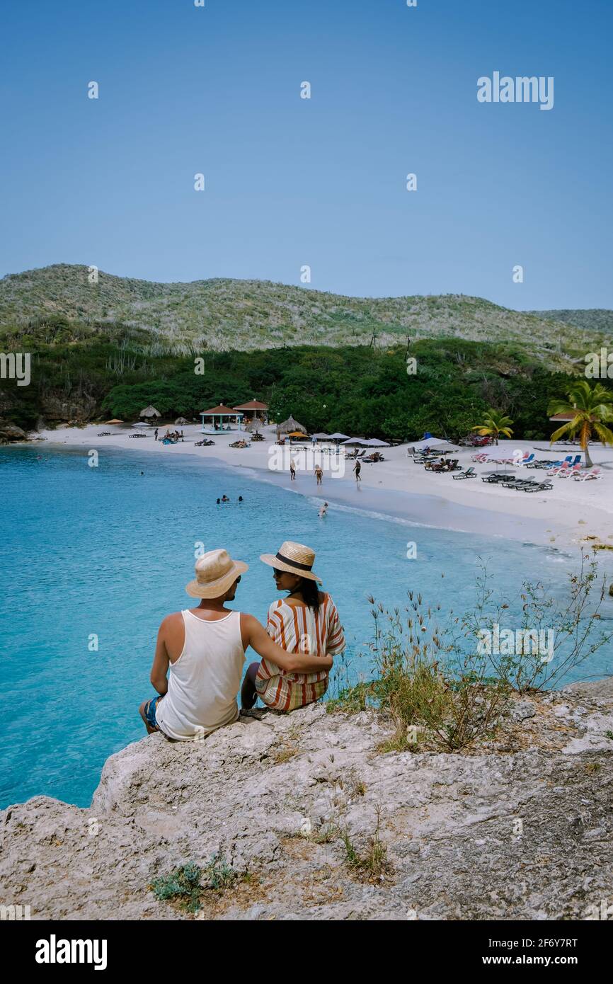Blick auf den weißen Strand Grote Knip, Curacao, Niederlande mit blauem Ozean Curacao Karibischer Strand mit Palmen, Paar Männer und Frauen, die Curacao im Urlaub am Strand besuchen Stockfoto