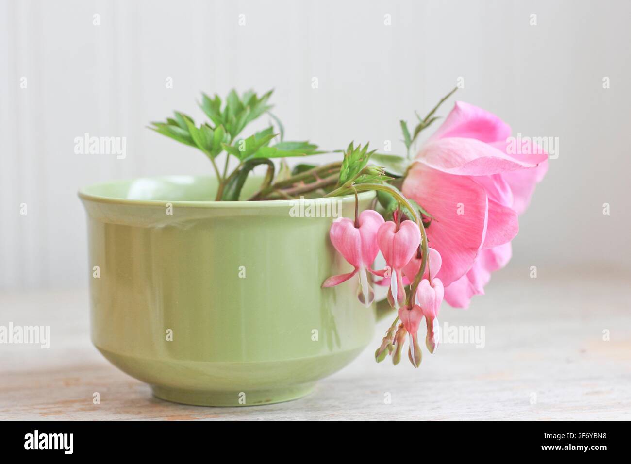 Wilde rosa Rose mit blutenden Herzen Blumen in Vintage-Tee stillleben im cup Stockfoto