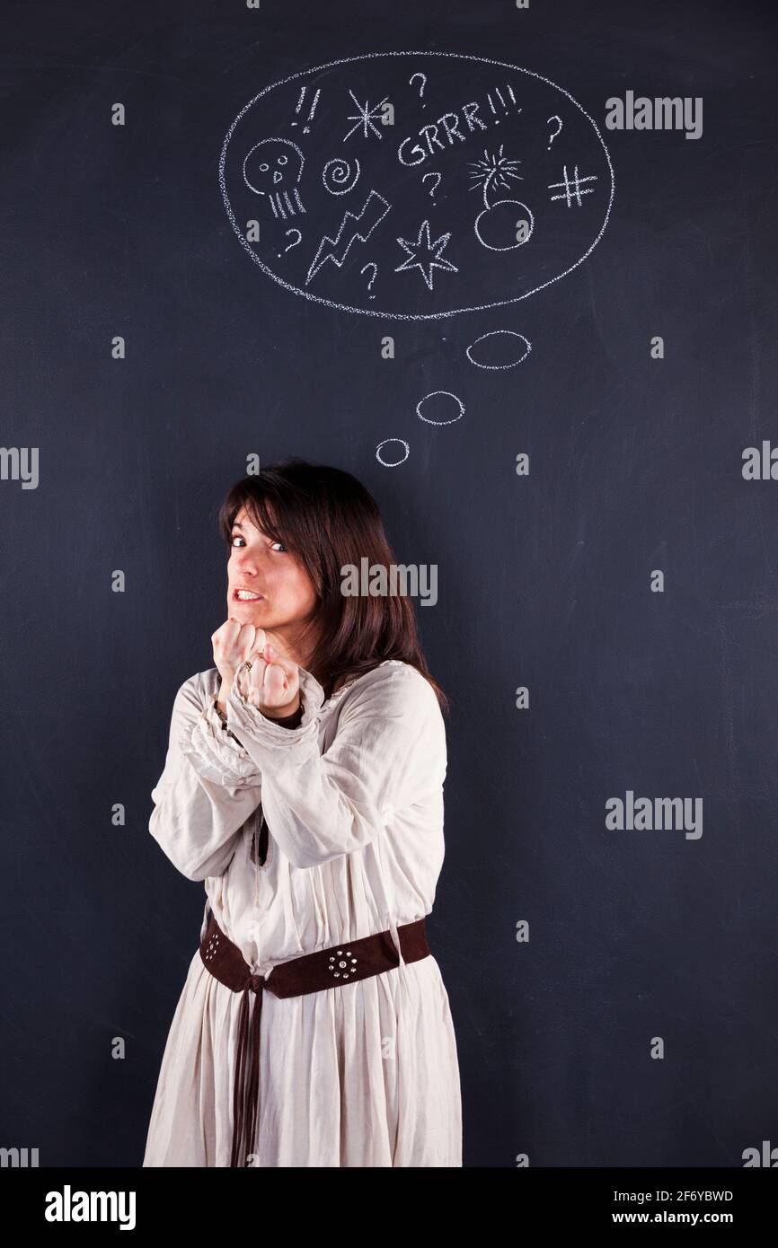 Wütende Frau neben einer Tafel, die ihre Emotionen zeigt Stockfoto