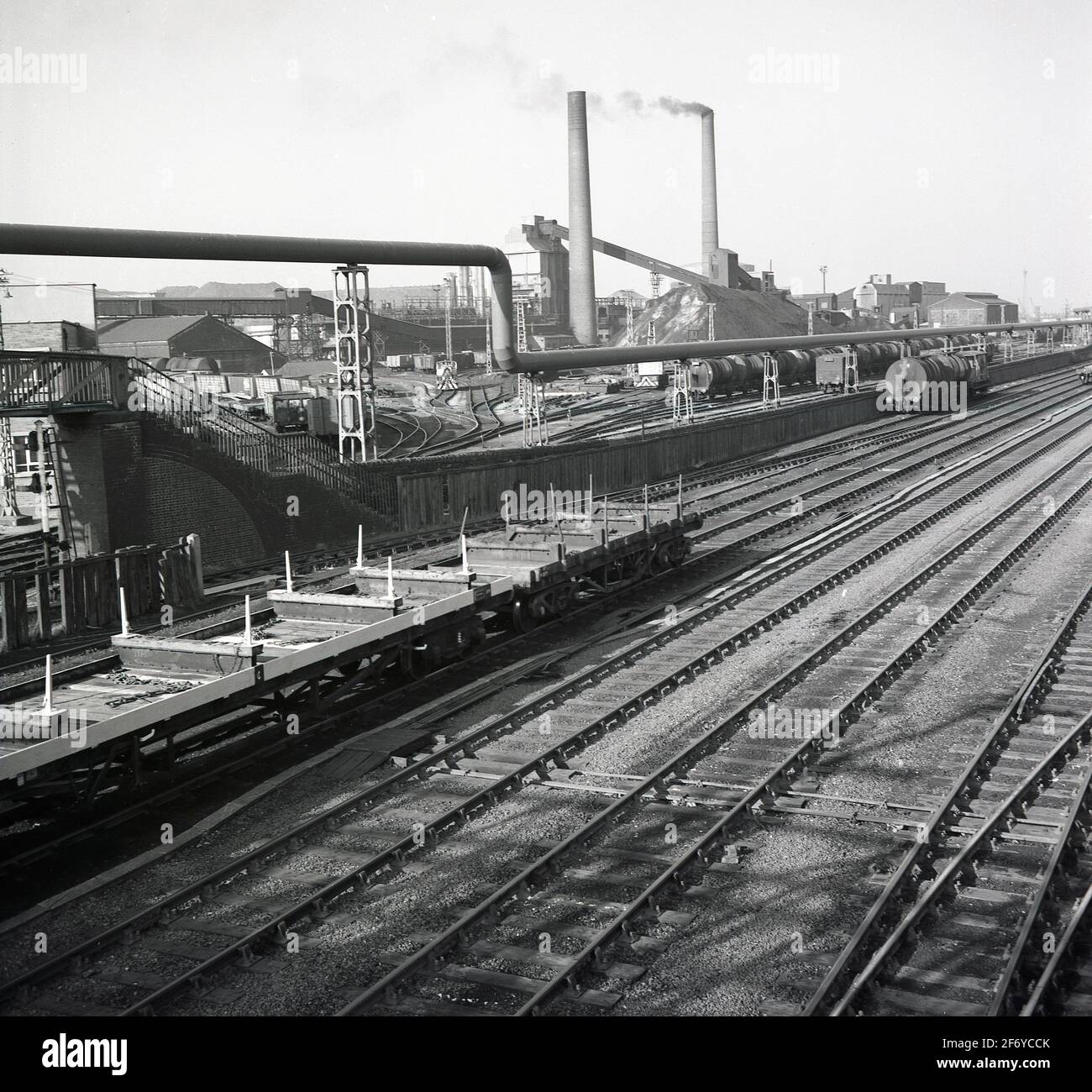 1950er Jahre, historische Ansicht einer Industrieeisenbahn und Gleise für Güterzüge, die ein großes Produktionswerk bedienen, England, Großbritannien. Solche Eisenbahnen waren einst ein gemeinsamer Standort in Großbritannien, wo Güterzüge schwere Massenrohstoffe entlang einer Strecke in andere Teile des Komplexes transporten. Das Wachstum des Straßenverkehrs und die Veränderungen im verarbeitenden Gewerbe haben dazu geführt, dass die Schienen- und Nebenstrecken für die Industrie rapide rückläufig waren. Stockfoto