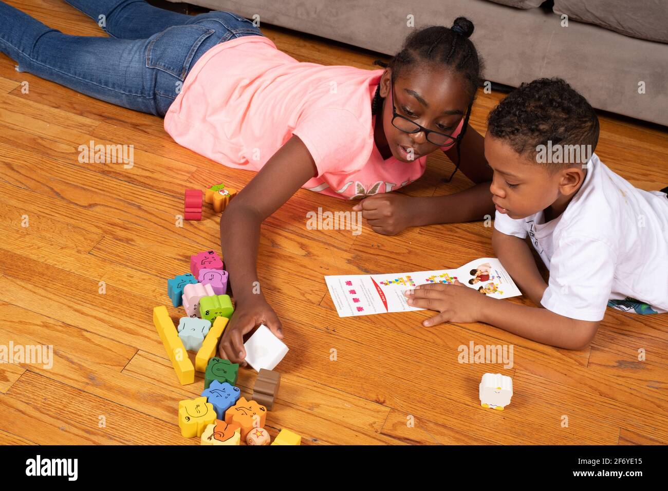 Mädchen, 11 Jahre alt, schaut mit ihrem 6-jährigen Bruder nach neuen Spielrichtungen Stockfoto