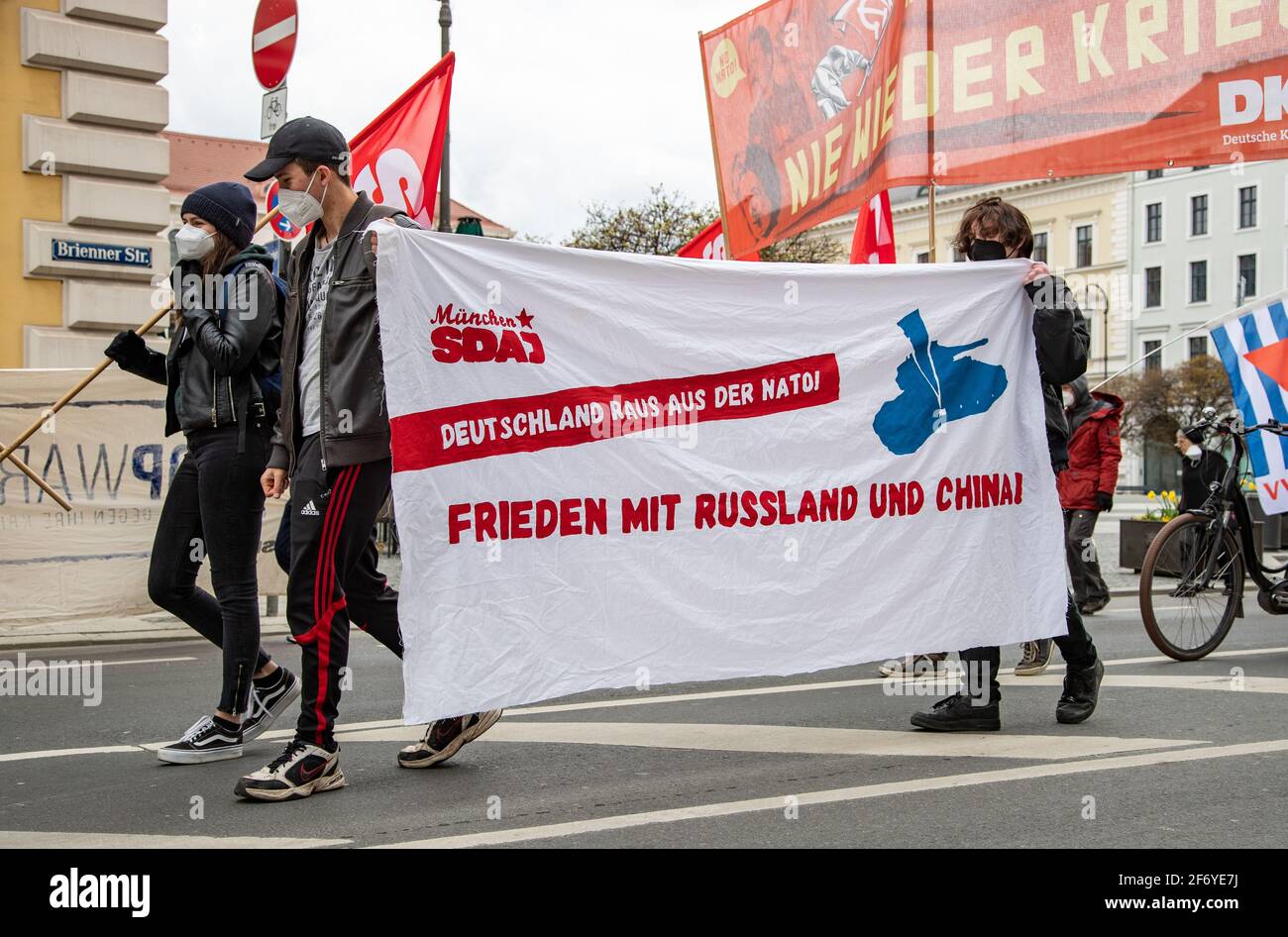 SDAJ mit Transsperent: „ Deutschland raus aus der NATO! Frieden mit Russland und China! Hundert Menschen sammeln sich am 3. April 2021 in München, um gegen Krieg und Aufrüstung und für eine atomwaffenfreie Welt zu demonstrieren. QUERDENKEN Gruppen hatten im Vorfeld dazu aufgerufen, den traditionellen Ostermarsch zu infiltrieren, die Veranstalter schlossen diese aber aus, so dass ohne Probleme demonstriert werden konnte. * SDAJ mit Transparent mit der Aufschrift: " Deutschland aus der NATO! Frieden mit Russland und China! Am 3 2021. April versammelten sich Hunderte in München, Deutschland, um gegen den Krieg zu protestieren Stockfoto