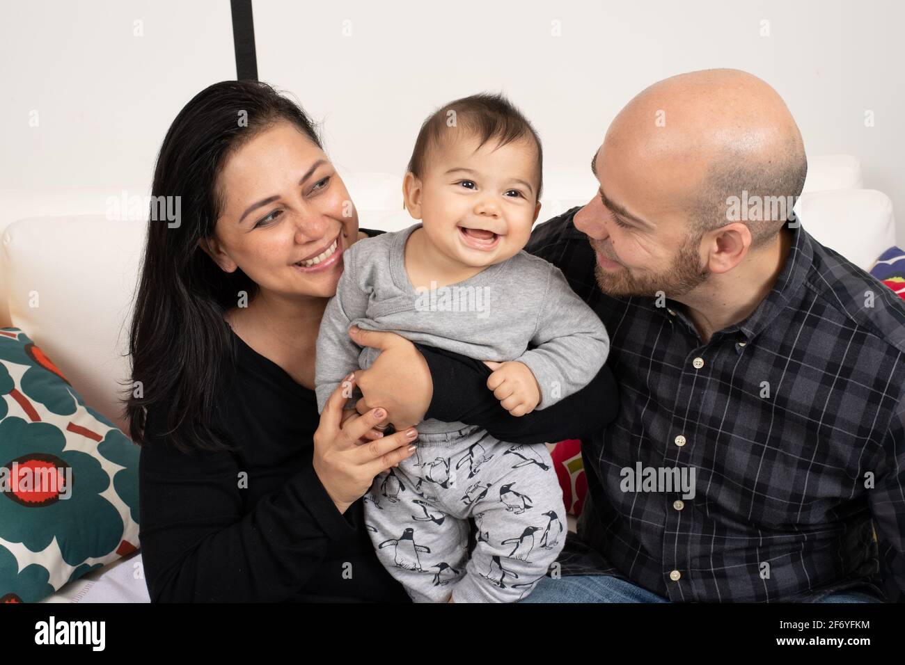 Sechs Monate alter Junge lachend Porträt mit seinen Eltern Stockfoto