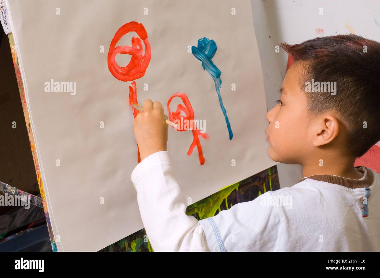 Bildung Vorschule 3-4 Jahre alt Junge Malerei an Staffelei malen Erkennbare menschliche Figuren Stockfoto