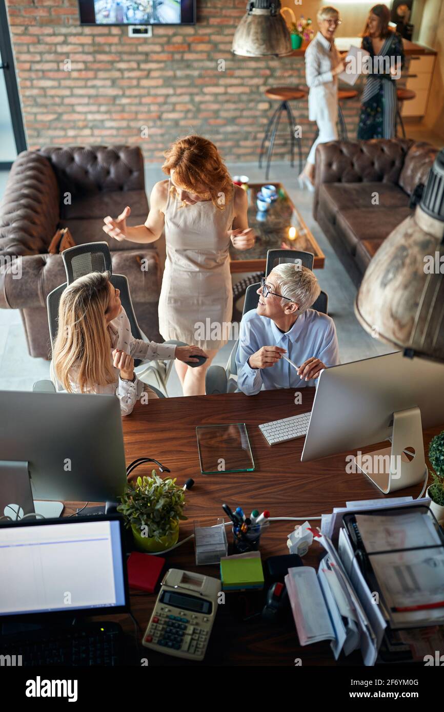 Glückliche erfolgreiche Frauen diskutieren gemeinsam im Büro Stockfoto