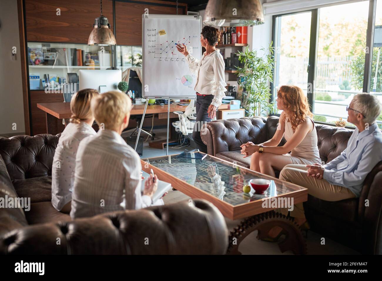 Eine hochrangige, leistungsstarke Geschäftsfrau hält eine Präsentation im Büro Stockfoto