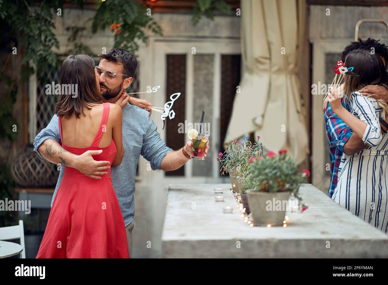 Paare in romantischen Momenten auf der Open-Air-Geburtstagsparty in einer schönen Sommerdämmerung. Gute Zeit der Freundschaft Stockfoto