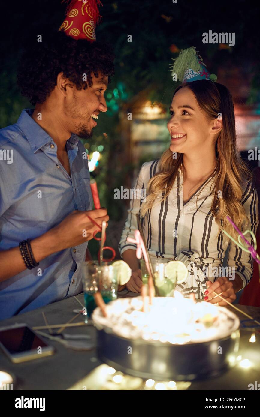 Glückliches Paar bei der Open-Air-Geburtstagsparty an einem schönen Sommerabend. Gute Zeit der Freundschaft Stockfoto