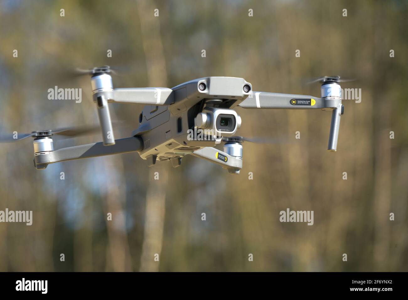Quadcopter Drohne schwebt vor einem Hintergrund von Bäumen Stockfoto